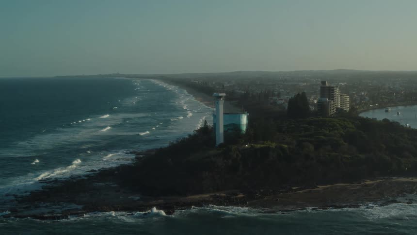 A peninsula with trees and a modern lighthouse tower