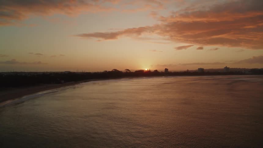 Aerial view of beach near the ocean at sunset