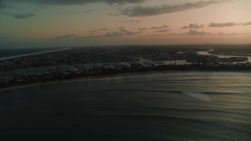 An aerial view of the ocean with buildings in the distance