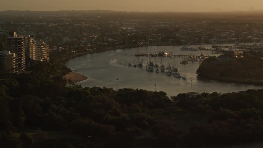 Boats sit docked along a river near downtown
