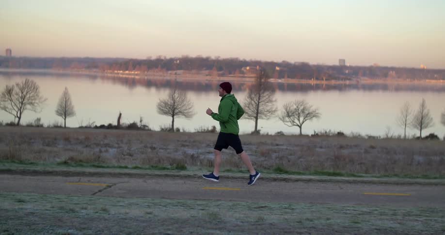 Person jogging a trail next to a lake