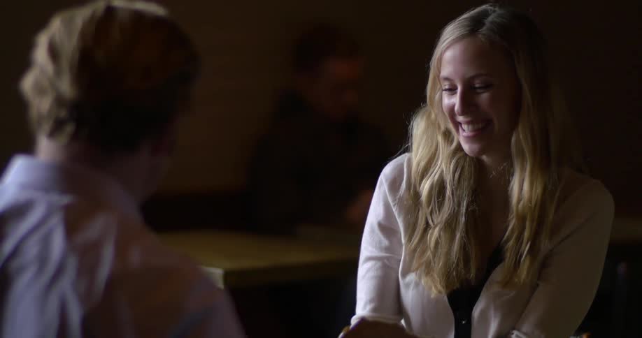 A man and woman talking and laughing at a table