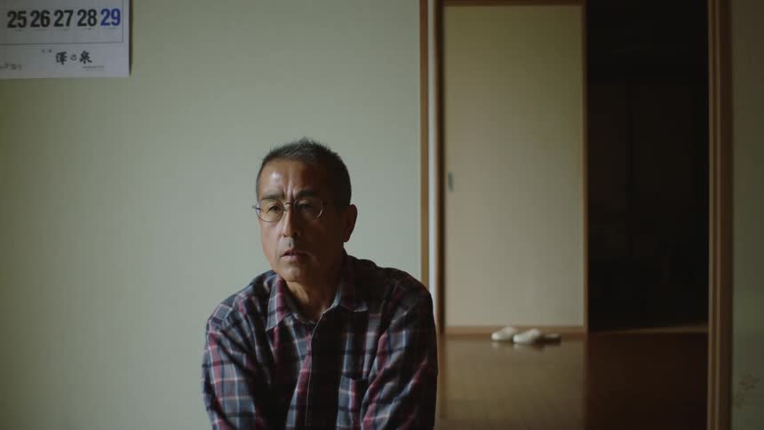 A man answers questions while sitting in front of an open door