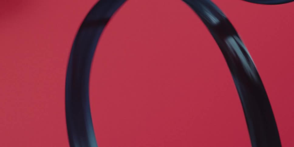 Spiral ribbon being twirled against a red background