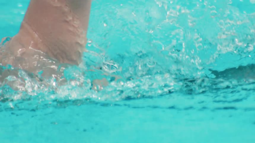 Person swims in a swimming pool