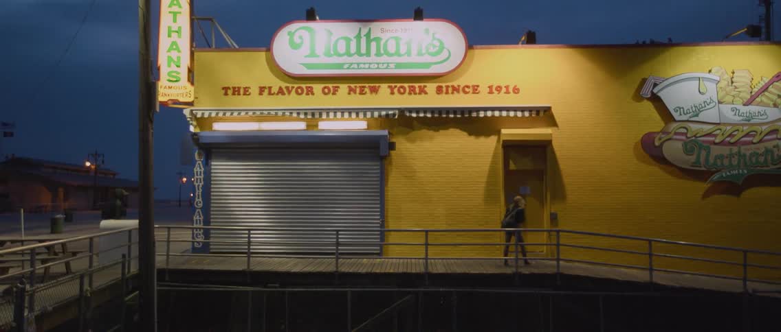 People walk by a closed nathan's hot dog stand