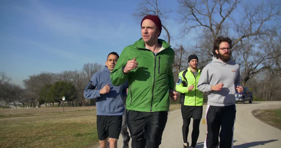A group of joggers run along a trail
