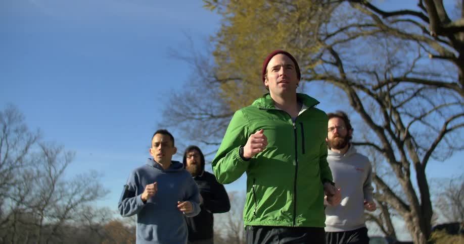 A group of men jogging together on a sunny day