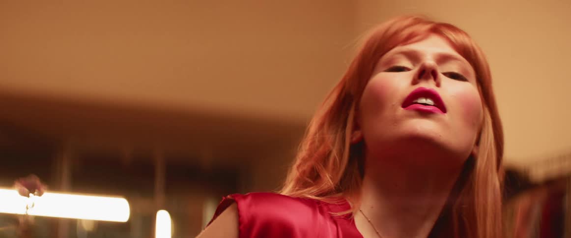 Woman tilts her head as she touches her hair