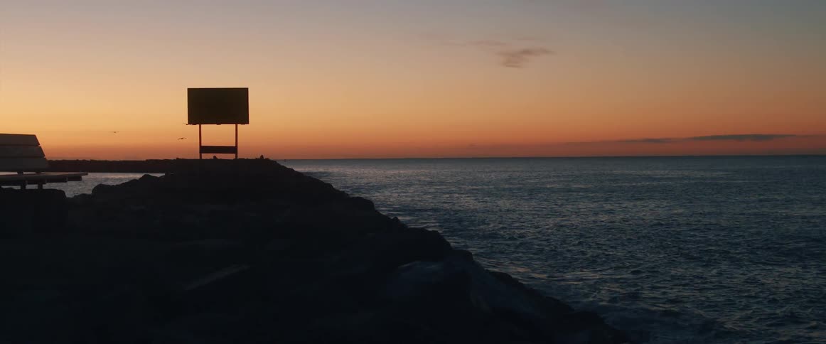The rock covered coast of a landmass at sunset