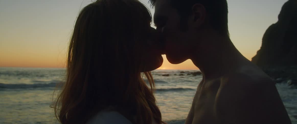 A man and woman kissing on the beach