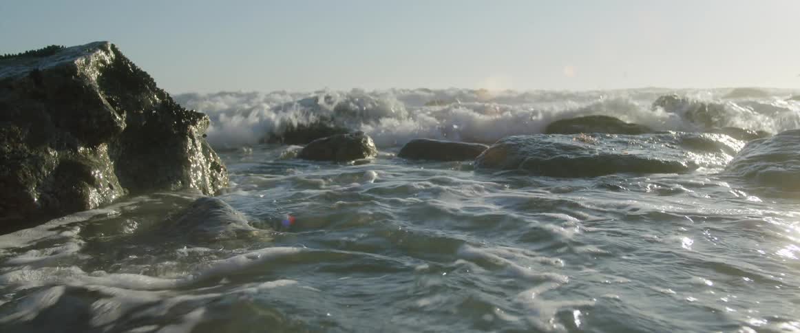 Ocean water is splashing on the rocks