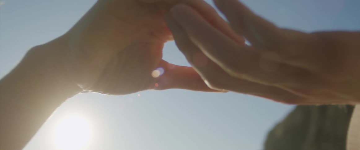 A couple outside holding hands and caressing each other