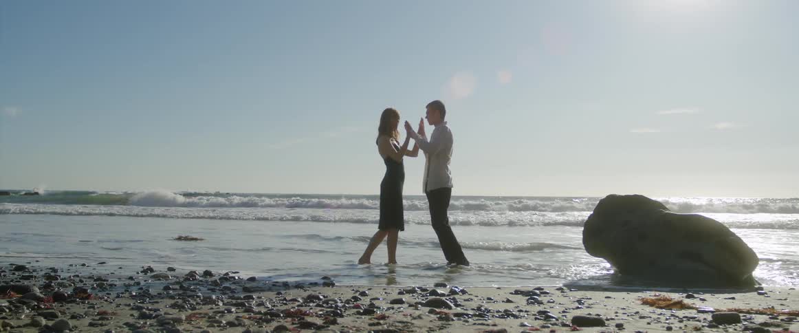 A man and woman are at the beach together