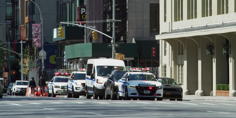 Police cars idling on city street at day