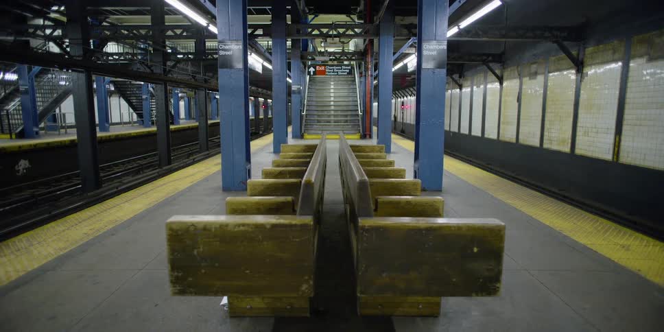 A subway platform with seats and staircases