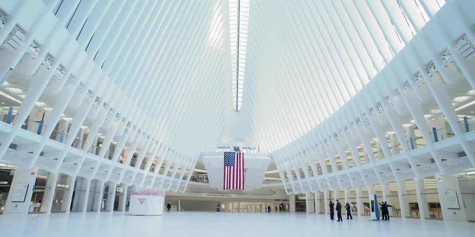Police wearing masks stand in a practically empty white terminal with an american flag hanging down