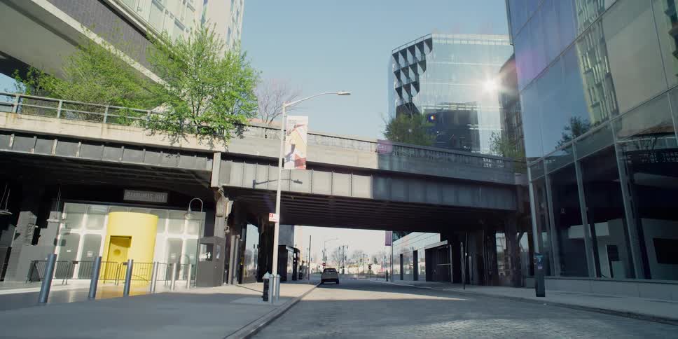 An empty city street passes under an overpass in downtown