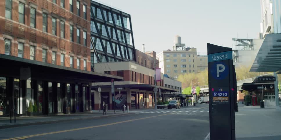 Empty street remains in shadows and sun shines on side of building