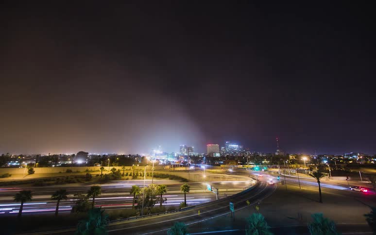 Dust cloud flowing over a city at night