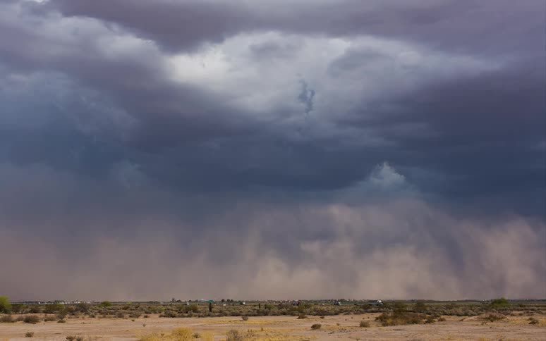 Time-lapse of traffic moving through flat land width storm clouds all around