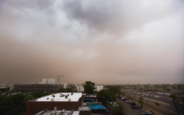 Time-lapse of a dust storm moving across an area with plenty of traffic