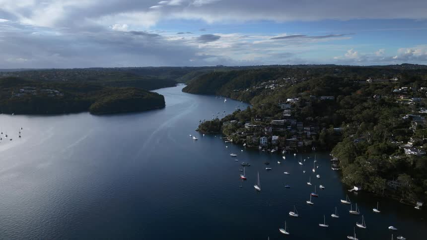 Many boats float in lake near coastal town