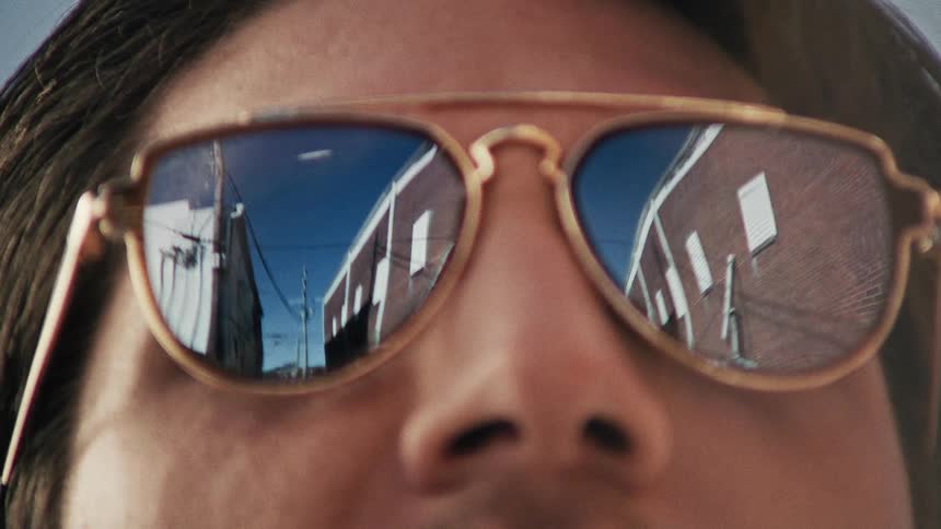 Close up of man with sunglasses looking at street