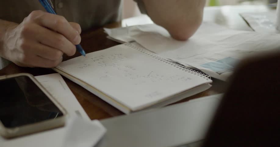 Man takes notes and adds up his bills becoming worried