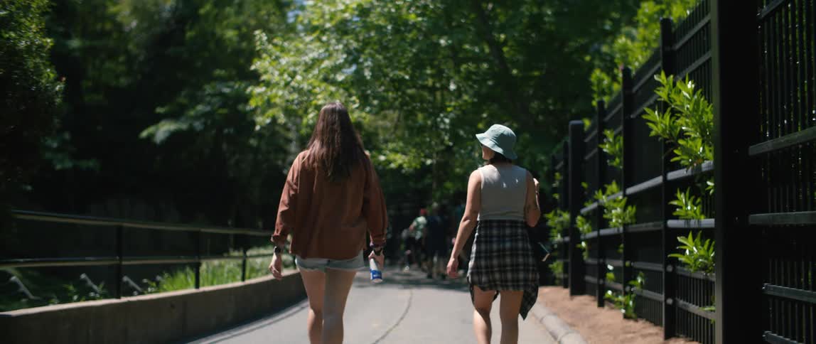 The view is of friends walking outdoors in the day time