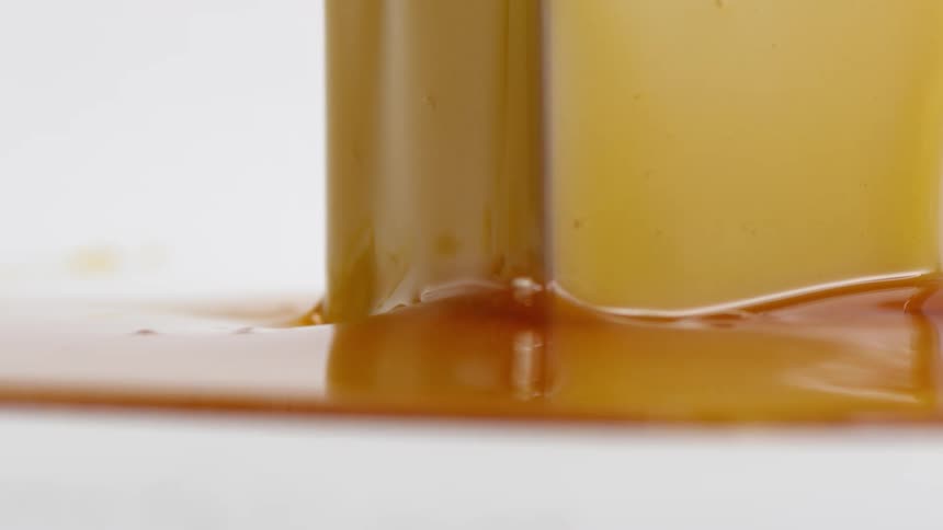A close up of hone in a glass and on a white counter