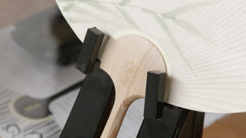 Close up of the handle of a paper fan
