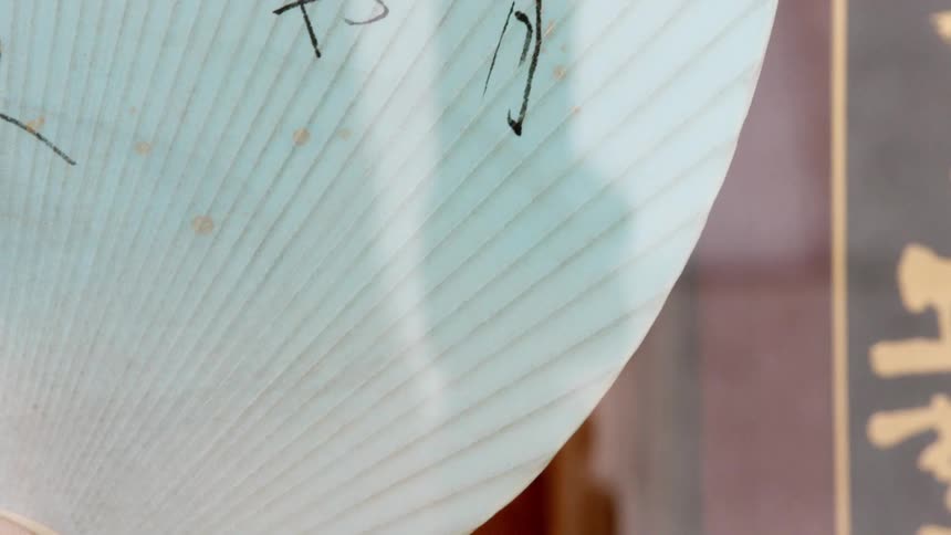 A sign has some foreign language lettering on a sunny day