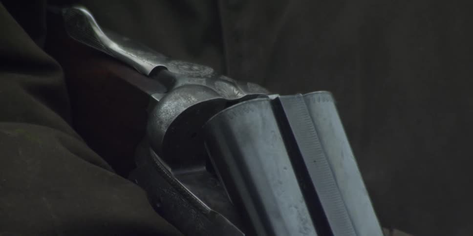 A man holds a shotgun with an open barrel
