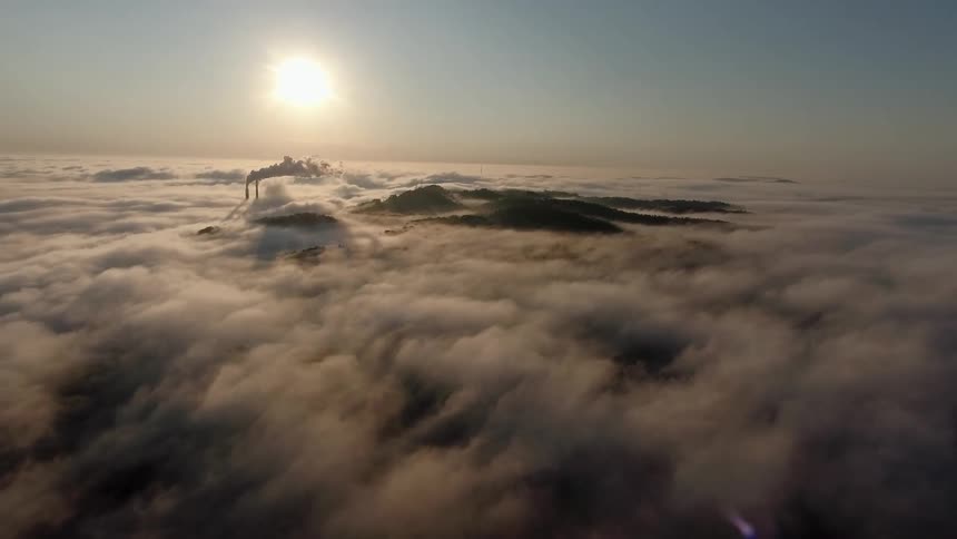 The sun shines over floating clouds