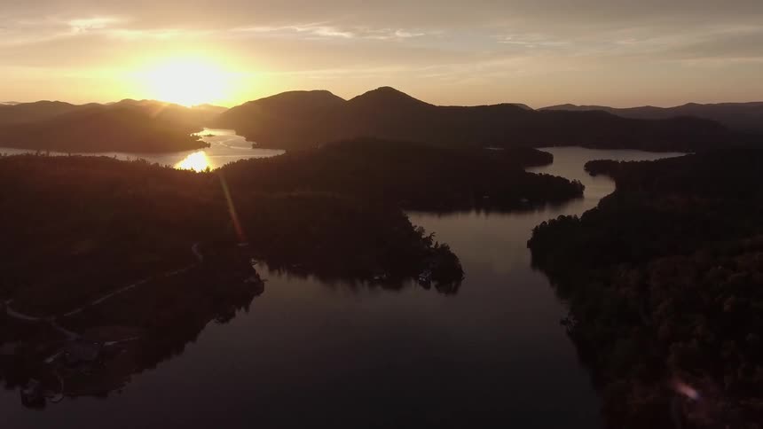 A lake leads to a mountain range at sunset