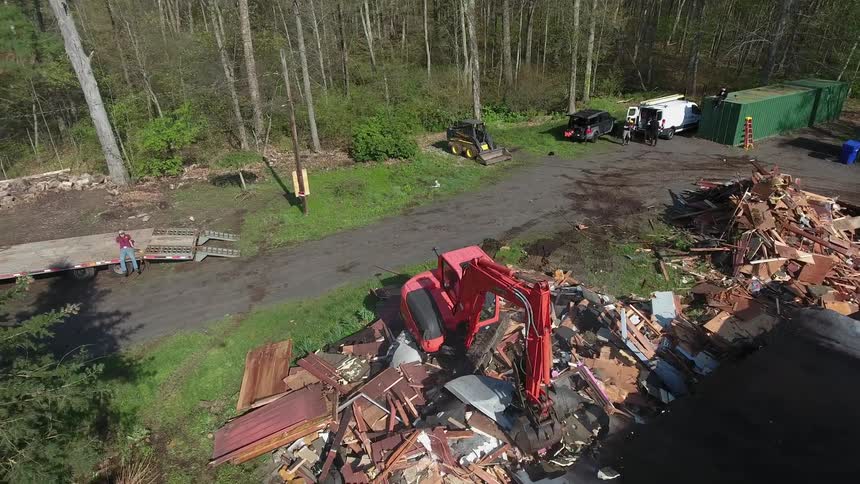 A construction vehicle is destroying a house
