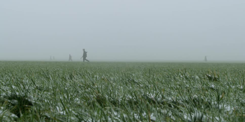 Soldiers walk across a snow covered plain