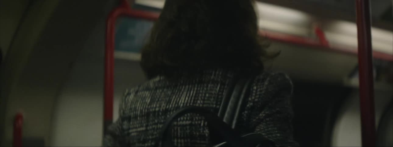 Young woman carrying backpack steps onto empty subway car and sits down
