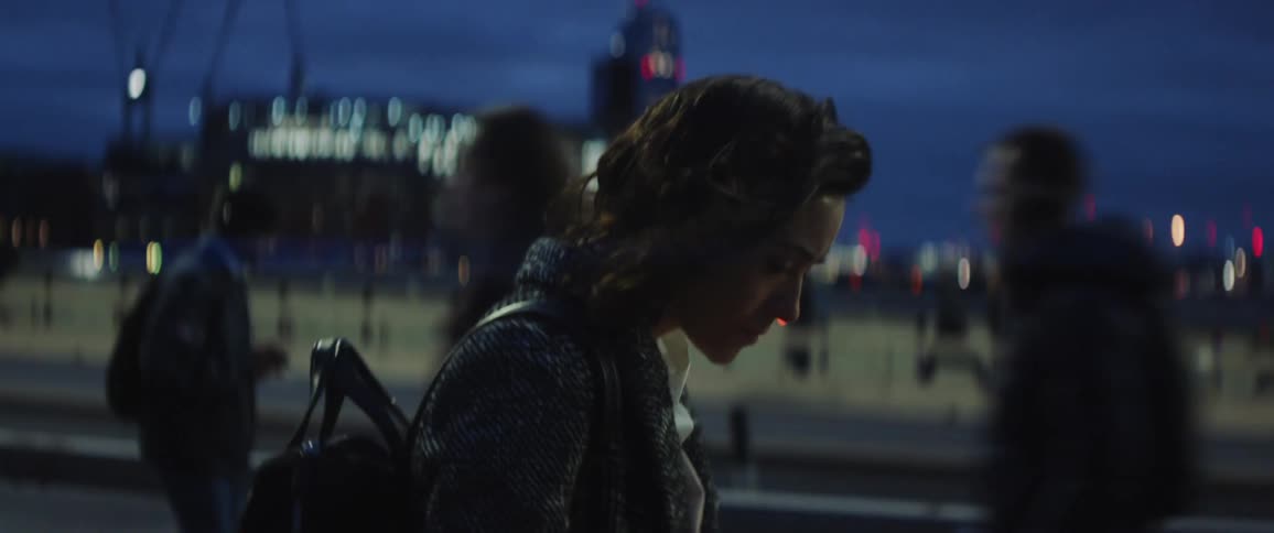 The view is of a woman that is walking outdoors at night time