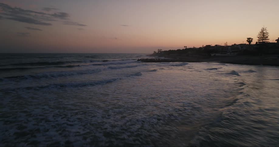 A beach at dusk small waves rippling towards the sand