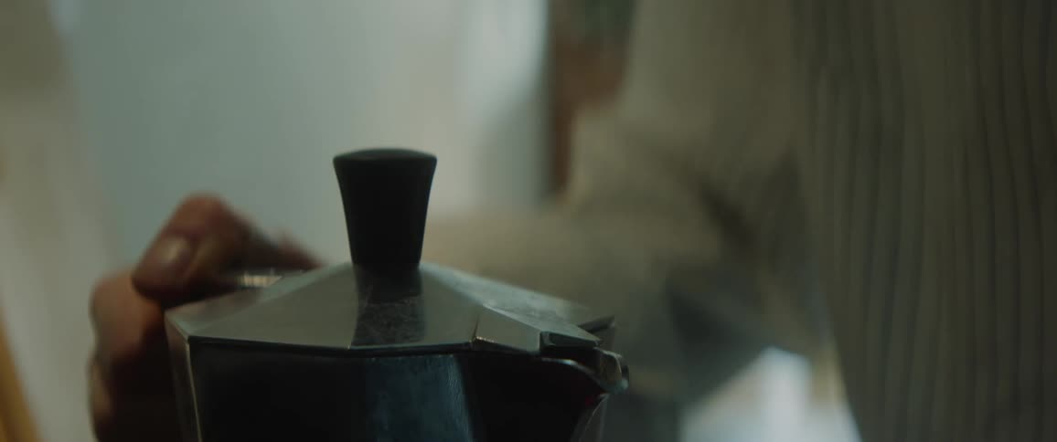 A person briefly opens the lid of a hot teapot and they pick it up and carry it away