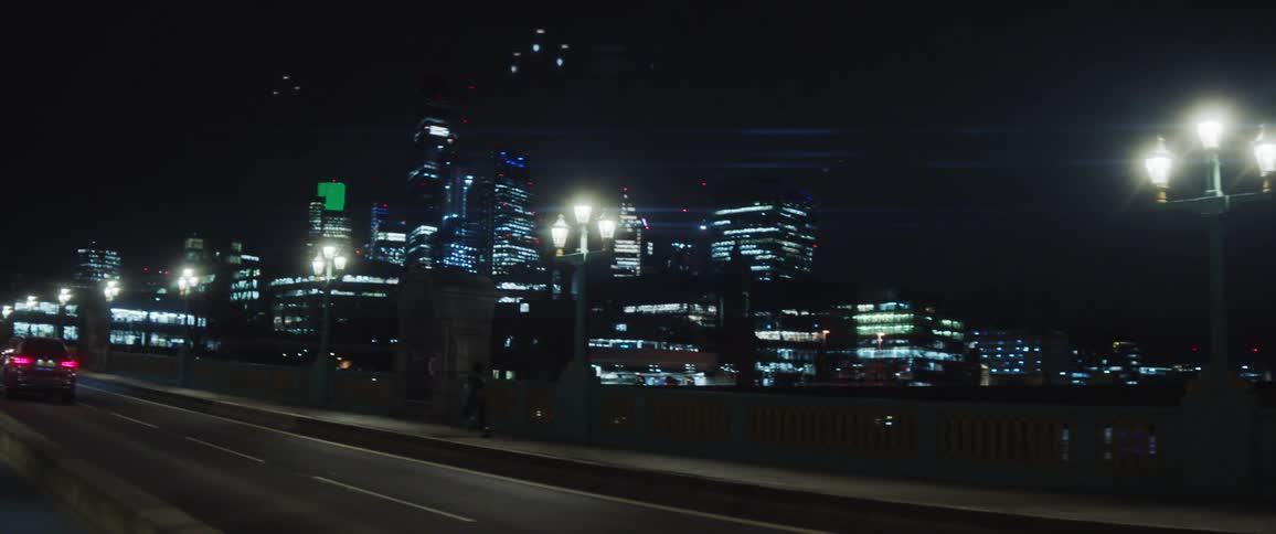 Woman happily runs and dances on the bridge against the city skyline at night