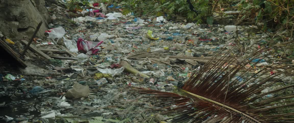 Looking across flood or hurricane damaged area with water and trash strewn about daytime