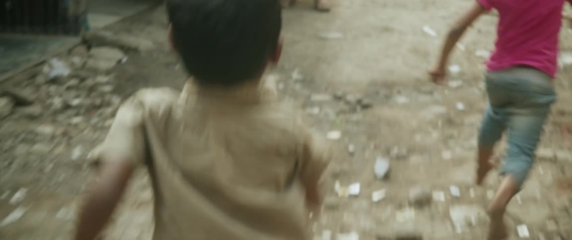 Two children running through a dirty street