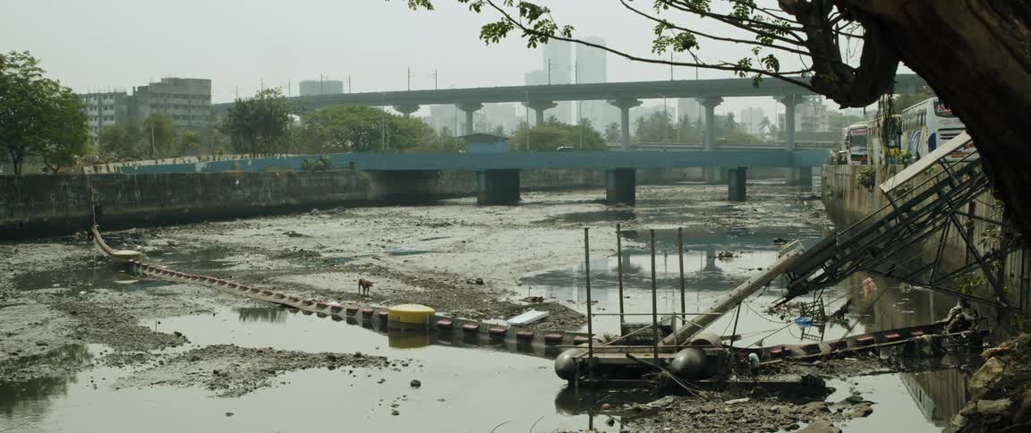Garbage litters a river through a city