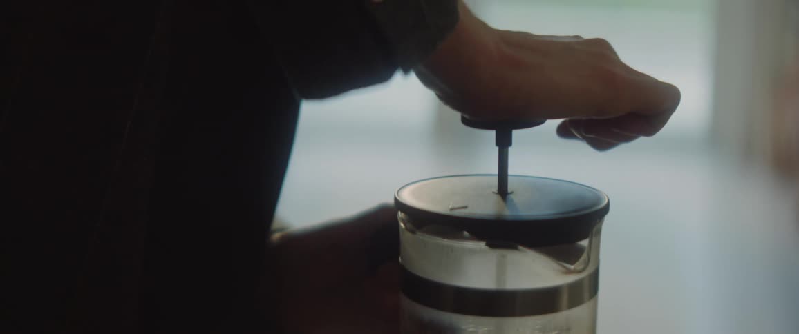 Person pushes down on french press before walking away