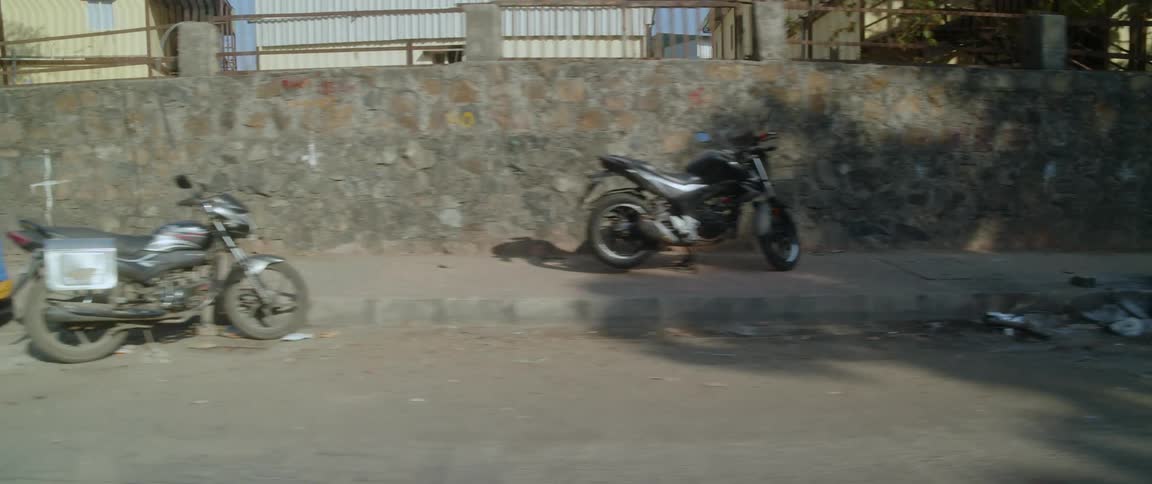 A sidewalk in a city with motorcycles on it and garbage strewn all over the streets