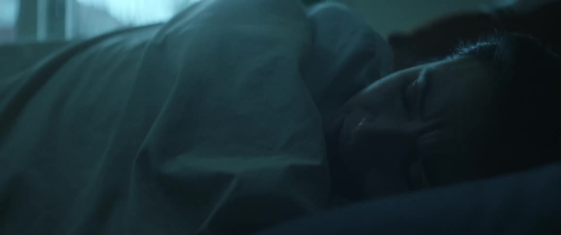 A woman yawns wide and rolls over as she wakes up