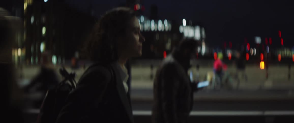 Young woman walking on the busy city streets at night